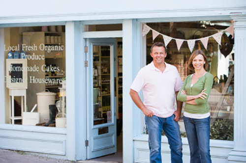 Store owners standing in front of their shop.